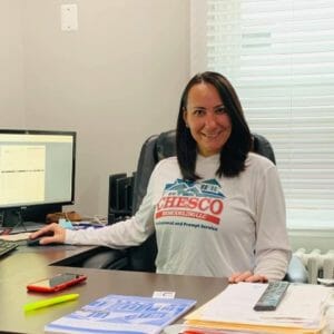 Mona Ramona sitting at her desk at chesco