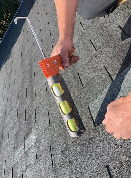 Man laying down asphalt shingles