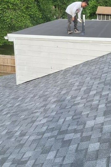 Employee working on an asphalt shingle roof